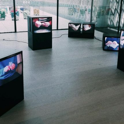 Large LED screens broadcasting live updates and schedules at a bustling trade show.