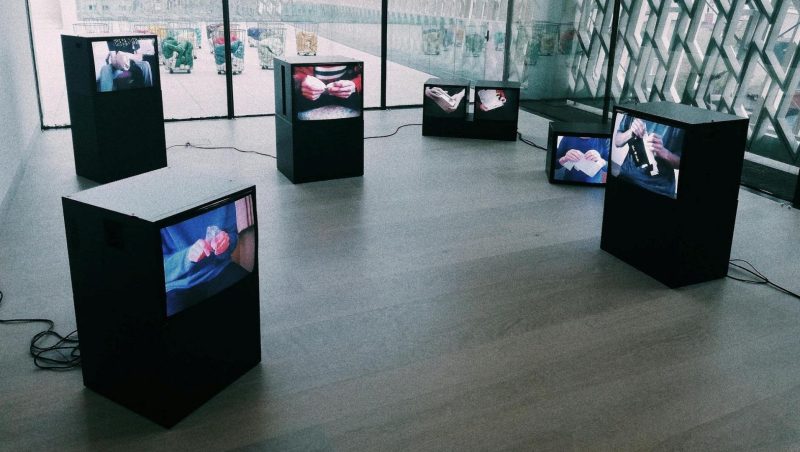 Large LED screens broadcasting live updates and schedules at a bustling trade show.